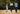 Family of four on a playground with wooden swings